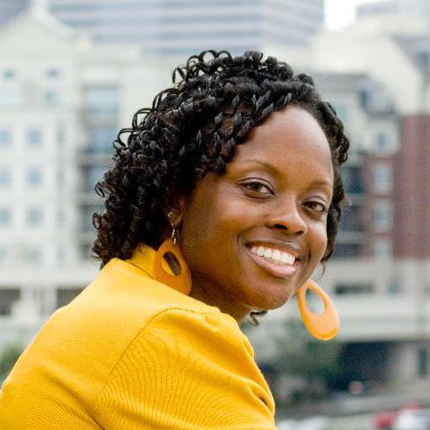 closeup of Shonté White, smiling, wearing a yellow blazer and yellow-orange earrings