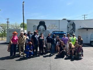 Group of individuals standing in front of a mural in Plaza Midwood