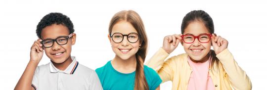 Three young children with glasses smiling