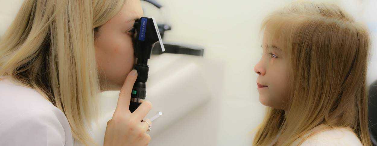 Doctor looking into a little girls eyes for a check up appointment